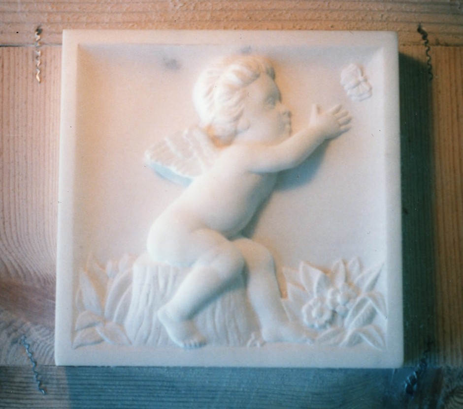 Cherub trying to catch a butteryfly carved in marble - cherub butterfly fire surround marble